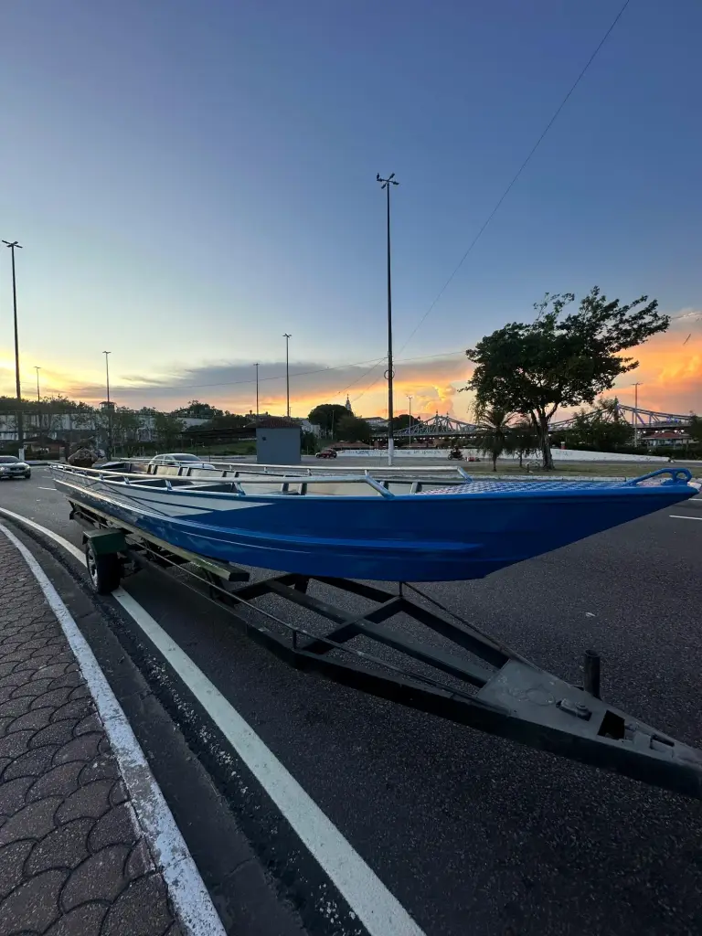 Canoa azul em reboque ao pôr do sol